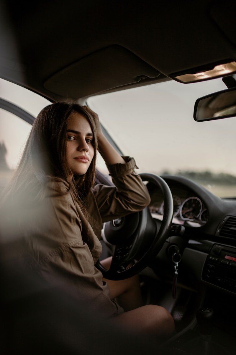 woman sitting inside car as a result of you adding a new driver to your insurance